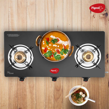 Cooking food in Pigeon Ayush 3 Burner High Powered Brass Gas Stove Cooktop with Glass Top and Stainless Steel Body (Black, Standard)